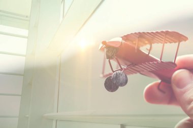 Elinde kırmızı oyuncak bir uçak var. tatil konsepti. Kırmızı oyuncak bir uçağı tutan ve hayalleri olan bir kadının elleri bir yolculuk olmak ister. 