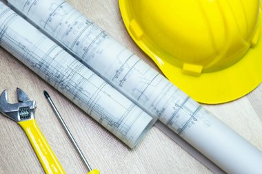 Bina planı ve sarı miğferli mimari arkaplan.