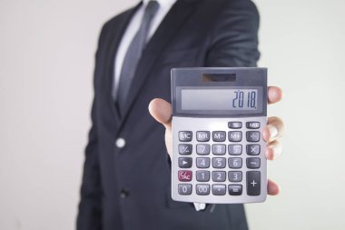 İş adamı hesap makinesi gösteriyor 