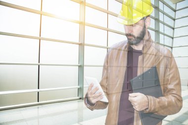 Tabletli kasklı genç mimar ya da mühendis.