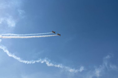Klasik çift kanatlı uçak duman izleriyle takla atar. Uçak gösterisi