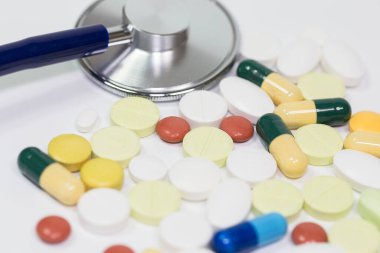 Tıbbi, tıbbi steteskop ve beyaz arka planda haplar. Sağlık hizmeti ya da hastalık. Hastanede ya da eczanede tablet ya da uyuşturucu. Kardiyoloji kalp tedavisi. İlaç reçetesi