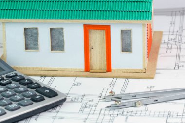 Mimari planlı, pusulası olan küçük oyuncak model ev. Mimarlık çalışma konsepti