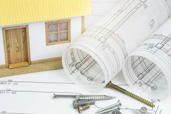 Small toy model house on architecture blueprint plan with a compass. Architect working concept