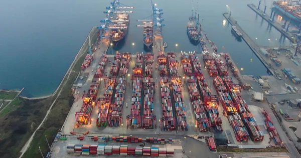 Gündoğumunda tersanede çalışan vinç köprüsü, lojistik ihracat ve ulaşım sektörü geçmişi olan konteyner kargo gemisi ve kargo uçağının lojistik ve taşımacılığı