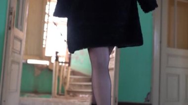 Terk edilmiş yaşlı bir evde poz veren genç bir kadın. 