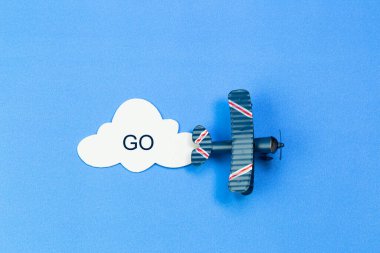 Kağıt bulutlu mavi gökyüzünün arka planında oyuncak uçak
