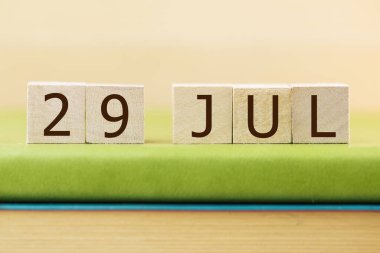 Wooden cubes calendar for 29 JULY on green book, closeupwooden,cubes,calendar,for,29,july,green,book,,closeup,