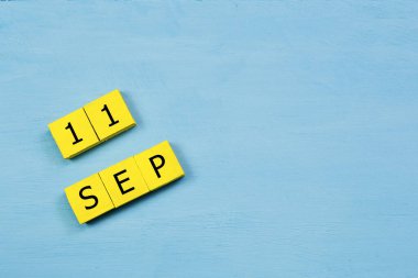 11 SEPTEMBER ve kopyalama alanı ile mavi ahşap yüzey üzerinde sarı küpler takvimi