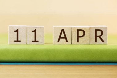 Ahşap küplerin takvimi 11 Nisan için yeşil kitap, yakın plan