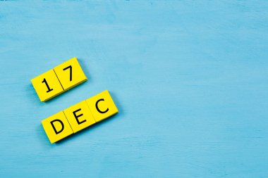 17 ARALIK ÖNCE ile mavi ahşap yüzeyde sarı küpler takvimi ve kopyalama alanı