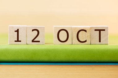 Yeşil kitap üzerine 12 Ekim küpleri takvimi, yakın plan.