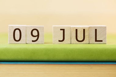 Yeşil kitap üzerine 09 Temmuz takvimi için ahşap küpler, yakın plan