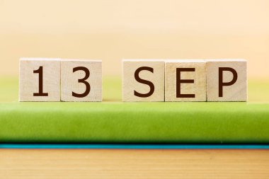 Yeşil kitap üzerine 13 Eylül takvimi için ahşap küp takvimi, yakın plan