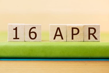 Tahta küplerin takvimi 16 APRIL için yeşil kitap, yakın plan