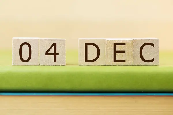 在绿皮书上贴上12月4日的木制方块日历 — 图库照片