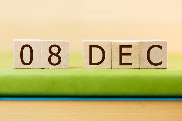 在绿皮书上贴上12月8日的木制方块日历 — 图库照片