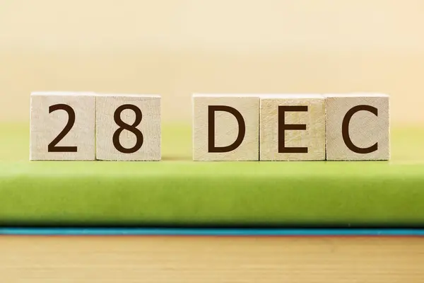 在绿皮书上贴上12月28日木方块日历 — 图库照片