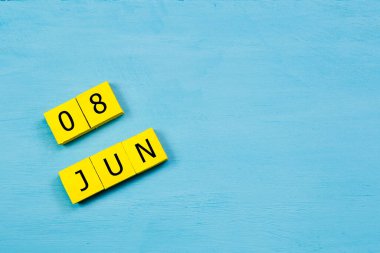 Mavi ahşap yüzeyli sarı küplü takvim 08 HAZİRAN ve kopyalama alanı