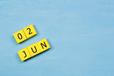 Mavi ahşap yüzeyli sarı küpler takvimi 02 HAZİRAN ve kopyalama alanı