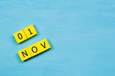 Mavi ahşap yüzeyde, 01 NOVEMBER ve kopyalama alanı içeren sarı küpler takvimi