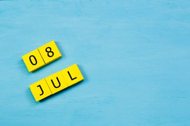 Mavi ahşap yüzeyde, 8 Temmuz 'lu sarı küpler takvimi ve boşluğu kopyala