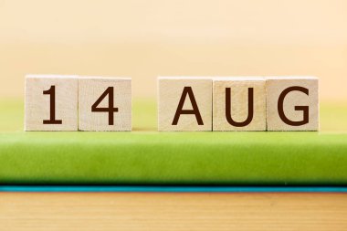 14 Ağustos takvimi için ahşap küp takvimi yeşil kitap, yakın plan