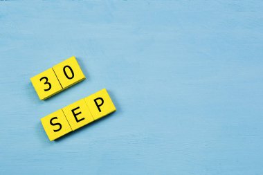 Mavi ahşap yüzeyde 30 SEPTEMBER ve kopyalama alanı içeren sarı küpler takvimi