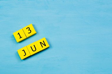 13 HAZİRAN ile mavi ahşap yüzeyde sarı küpler takvimi ve kopyalama alanı