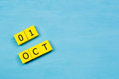 Mavi ahşap yüzeyde, 01 Ekim tarihli sarı küpler takvimi ve boşluk kopyala