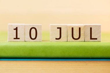 Ahşap küplerin takvimi 10 Temmuz 'da yeşil kitapta, yakın plan.