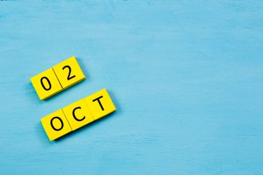 Mavi ahşap yüzeyli sarı küpler takvimi 02 Ekim ve boşluğu kopyala