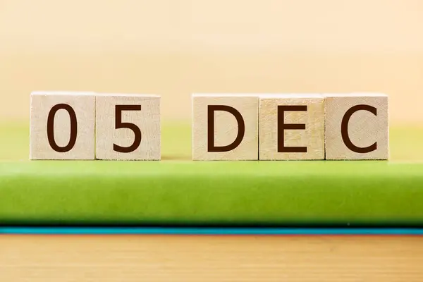 在绿皮书上贴上12月5日的木制方块日历 — 图库照片