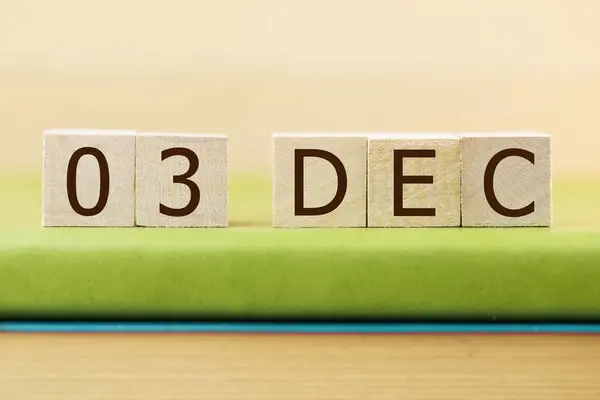在绿皮书上贴上12月3日的木制方块日历 — 图库照片