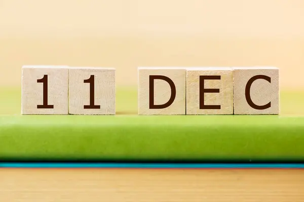 在绿皮书上贴上12月11日的木制方块日历 — 图库照片