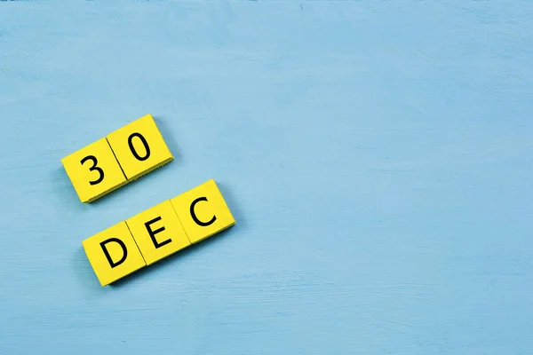 12月30日蓝色木制表面的黄色方块日历及复制空间 — 图库照片