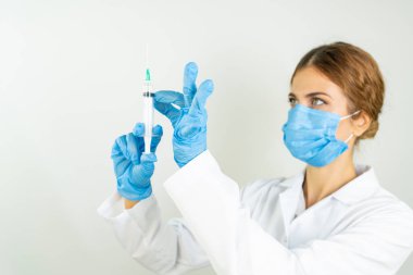 Sıvı aşılarla dolu bir şırıngayı laboratuvarda tutan doktor ya da bilim adamı olan Covid-19 Corona virüsüne karşı kavramsal mücadele: hastalıklar, tıbbi bakım, bilim