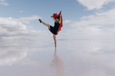 Kırmızı tüllerle gölde dans eden modern bir genç dansçı..