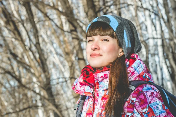 La chica de la chaqueta brillante camina en el bosque de invierno — Foto de Stock