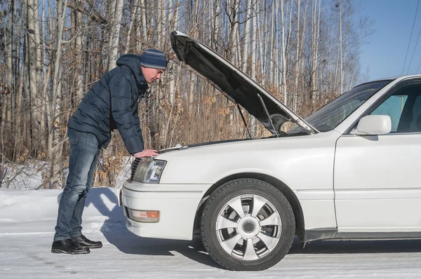 O homem repara um carro branco. Carro partido Fotos De Bancos De Imagens Sem Royalties