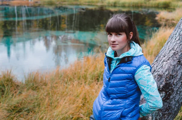 Menina em um fundo de lagos de montanha azul olhar para a câmera Imagens De Bancos De Imagens