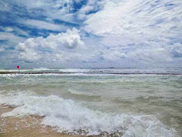 Storm on the sea. A red flag warns of the dangers of swimming. — Stock Photo, Image