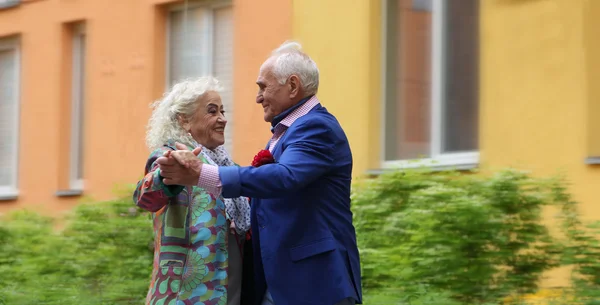 Ein älteres Paar tanzt auf der Straße. Walzer im Freien. Wahre Liebe. — Stockfoto