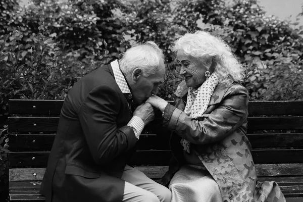 Пожилой мужчина целует руки пожилой женщины. Черное и белое . — стоковое фото