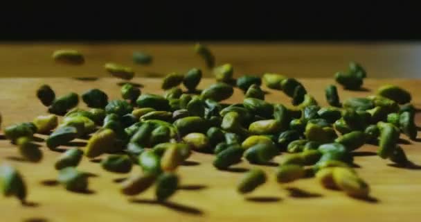 Pistaches fraîches de la sicile en italie tombent dans une table en bois dans un ralentissement extrême — Video