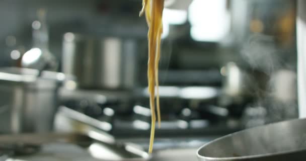 Chef usando tenedor profesional para poner pasta italiana en un plato en cámara lenta extrema — Vídeo de stock