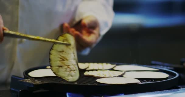 Chef exper parrilla italiana algunas berenjenas en cámara lenta extrema en ambiente romántico — Vídeos de Stock