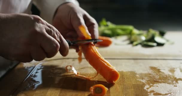 Експерт шеф-кухар чистить біологічну моркву в старому традиційному стилі в екстремальному супер повільному русі — стокове відео