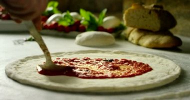 very italian style old tradition food in extreme slow motion close up of a expert making tomato souce pizza
