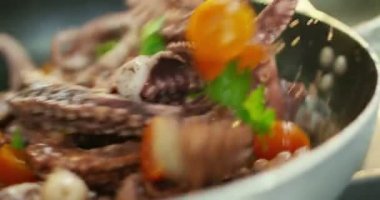 Super slow motion macro of a flipping octopus and vegetables with a pan (close up)